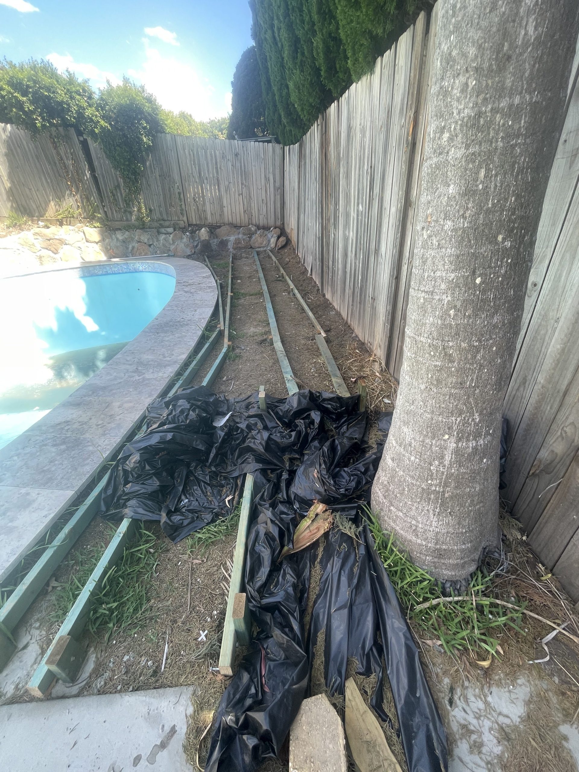 Pool surround with synthetic grass — before